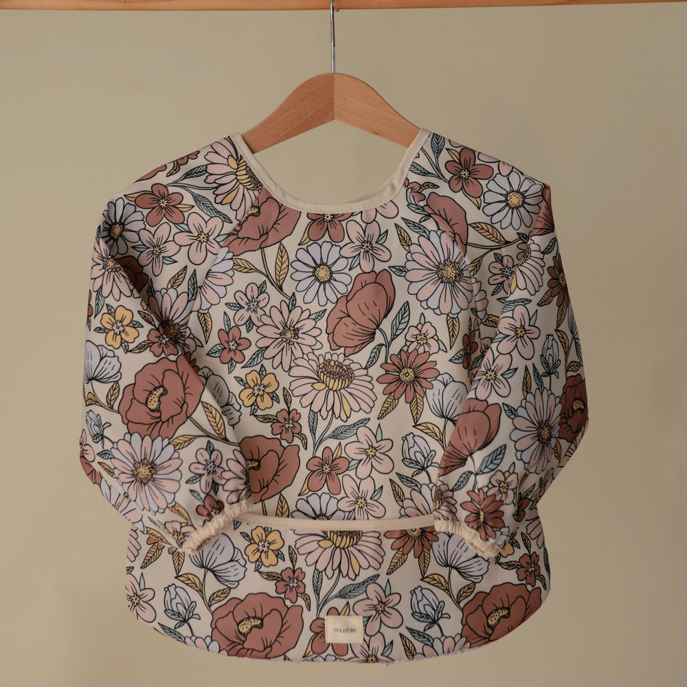 Mushie bib pocket catches crumbs and spills efficiently during feeding