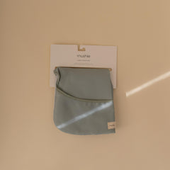 Mushie long sleeve bib in Roman Green demonstrates secure Velcro neck closure