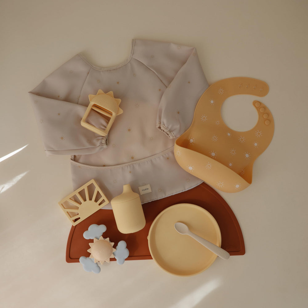 Mushie long sleeve bib sun wide pocket catches crumbs and spills