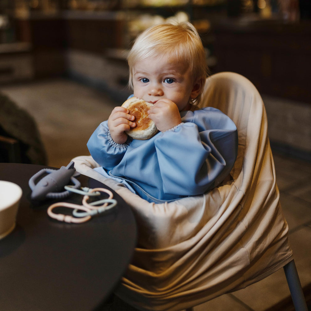 Tradewinds bib displays size 6-24 months for adjustable fit.