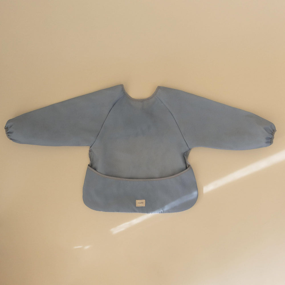 Mushie Tradewinds bib with Velcro closure eases on and off.