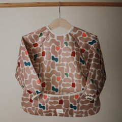 Mushie long sleeve bib with velcro neck close keeps outfit protected