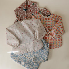 Mushie long sleeve bib wide pocket catches crumbs and spills