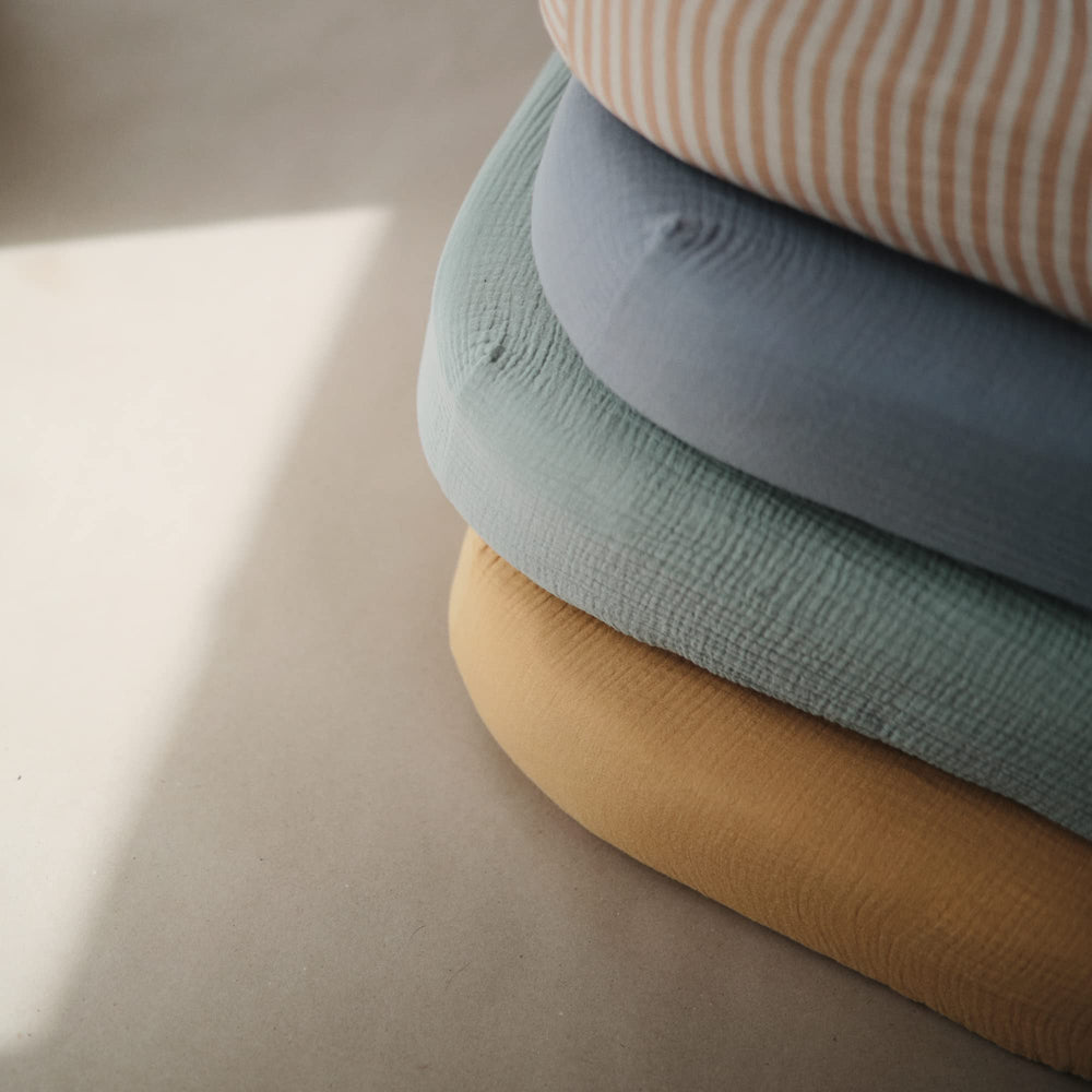 Mushie muslin fabric close-up highlights breathable weave for comfortable sleep.