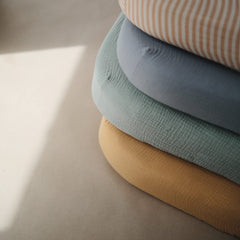 Mushie muslin fabric close-up highlights breathable weave for comfortable sleep.