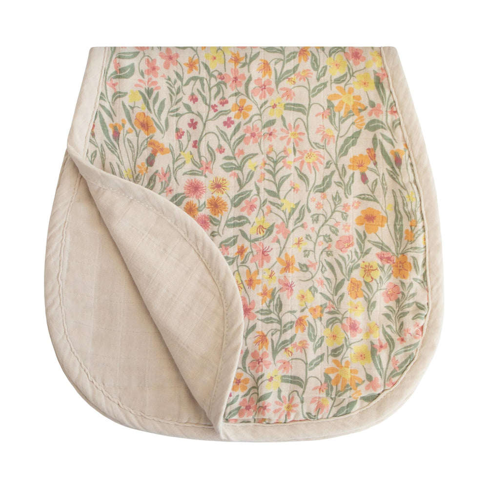 Mushie muslin burp cloth in pastel blooms close-up shows soft organic cotton texture.