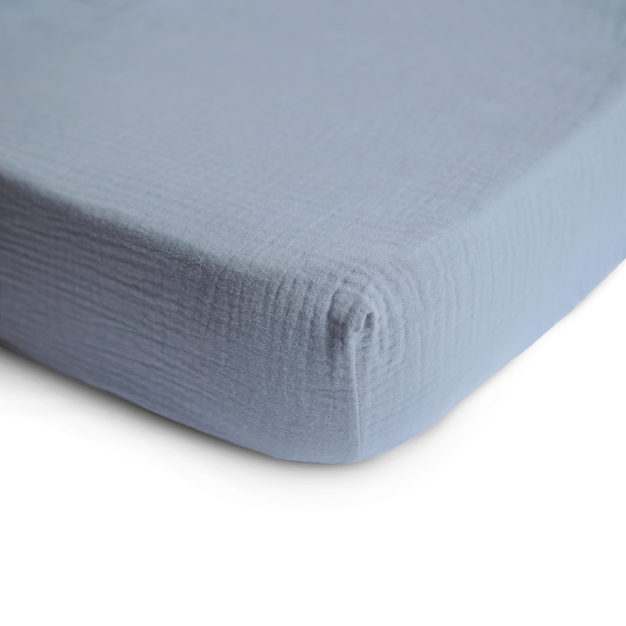 Mushie muslin fitted mini crib sheet Tradewinds shows elastic edges for secure fit