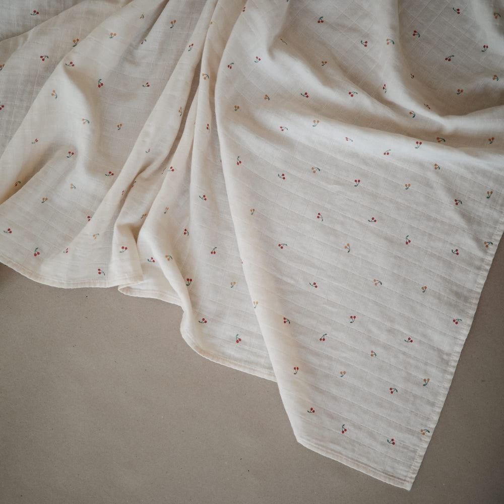 Mushie muslin swaddle blanket in nursery scene demonstrates breathable fabric for cozy naps