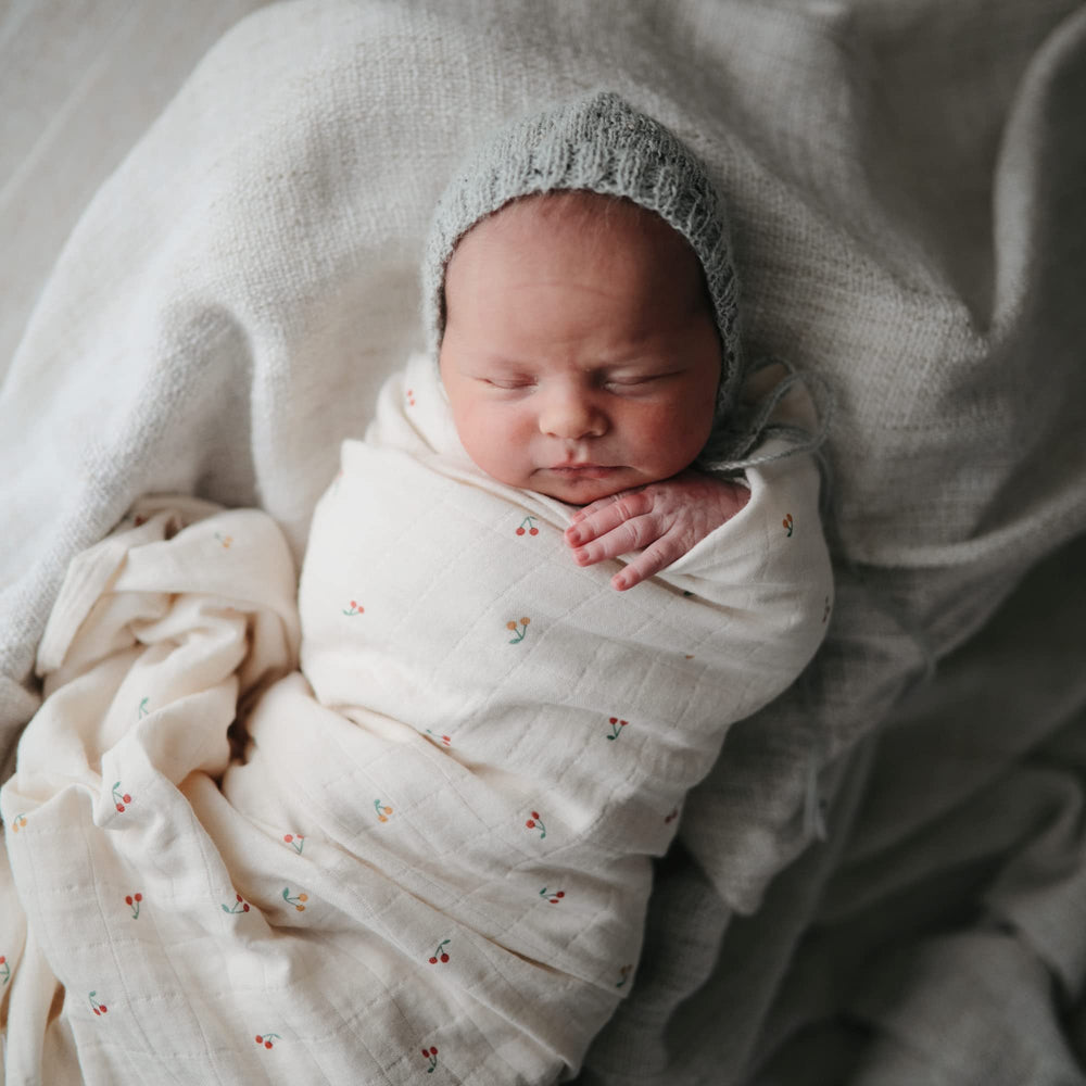 Mushie swaddle blanket shown for secure swaddling and calm baby moments