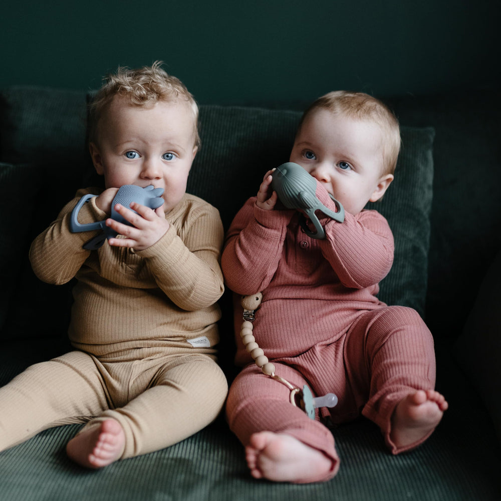 Mushie No-Drop Dino Teether color variants illustrate gentle visual appeal for infants.