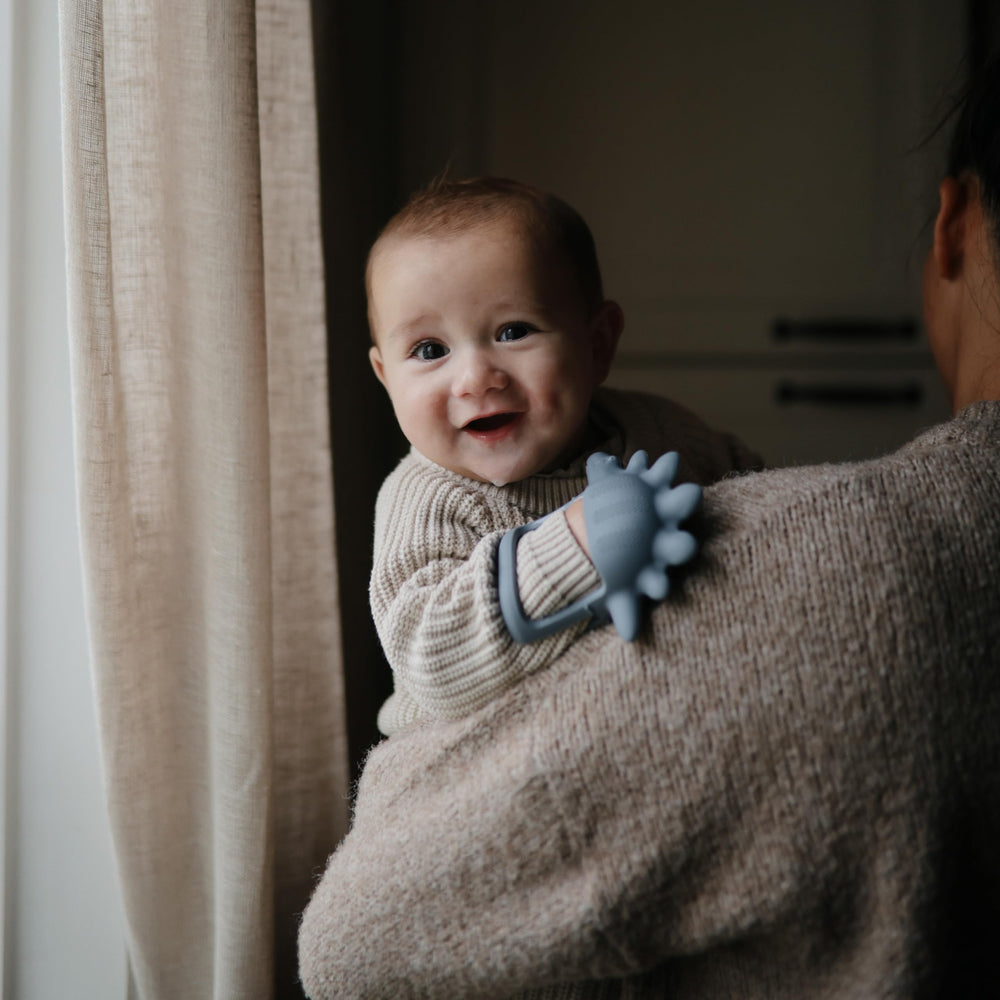 Mushie No-Drop Dino Teether textured surface supports oral exploration for babies.