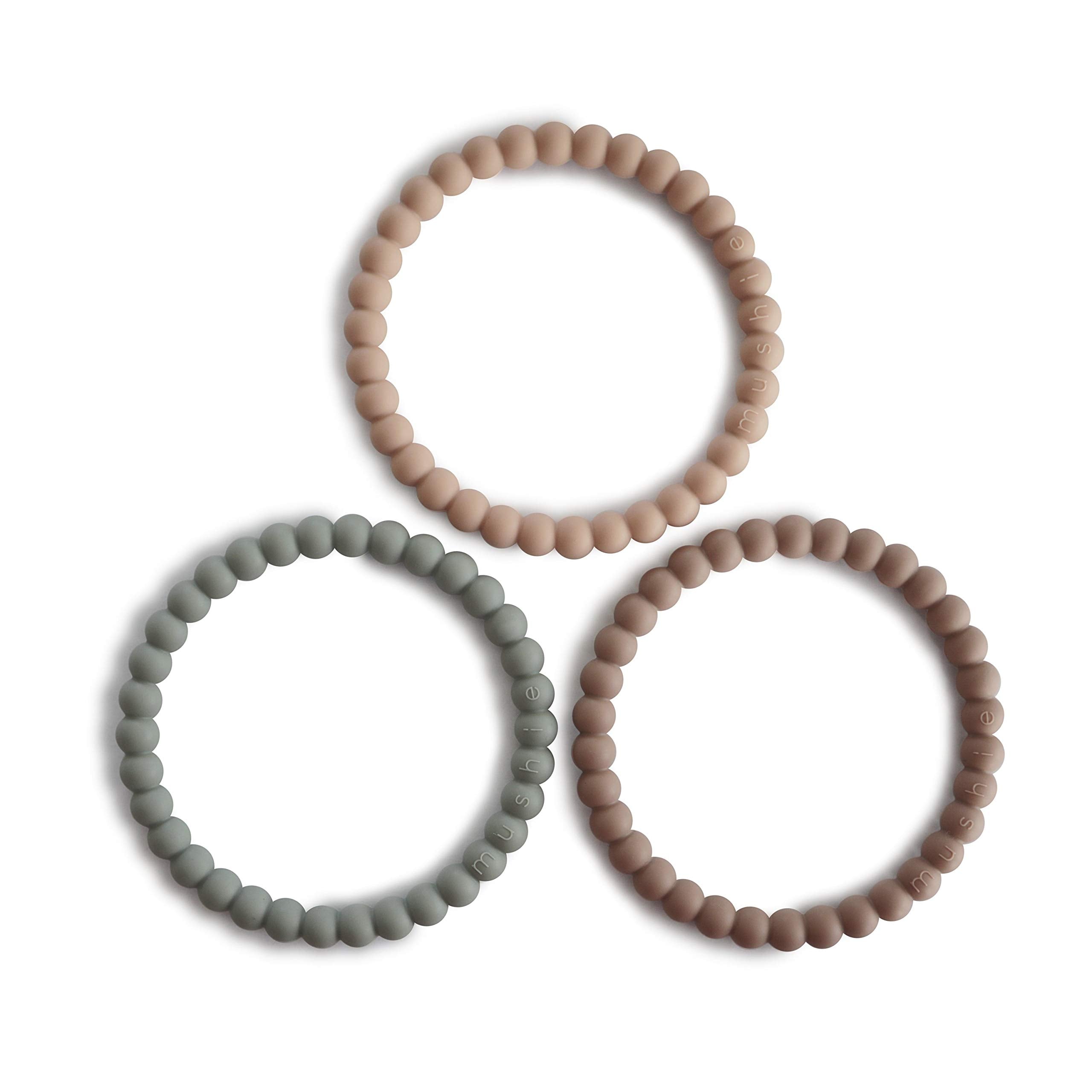 Mushie Pearl Teether Bracelet in Clary Sage on baby hand for soothing gums