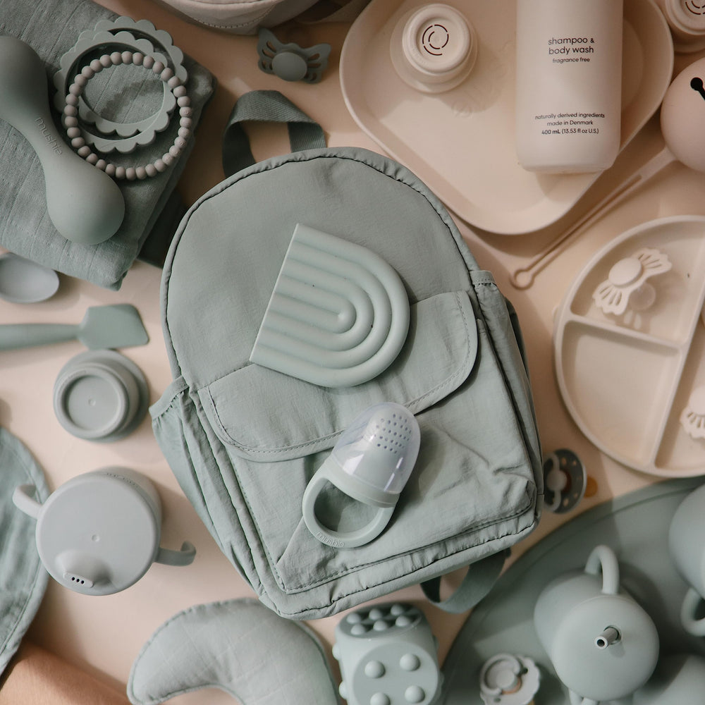 Mushie silicone feeder demonstrates safe self-feeding for little mouths.
