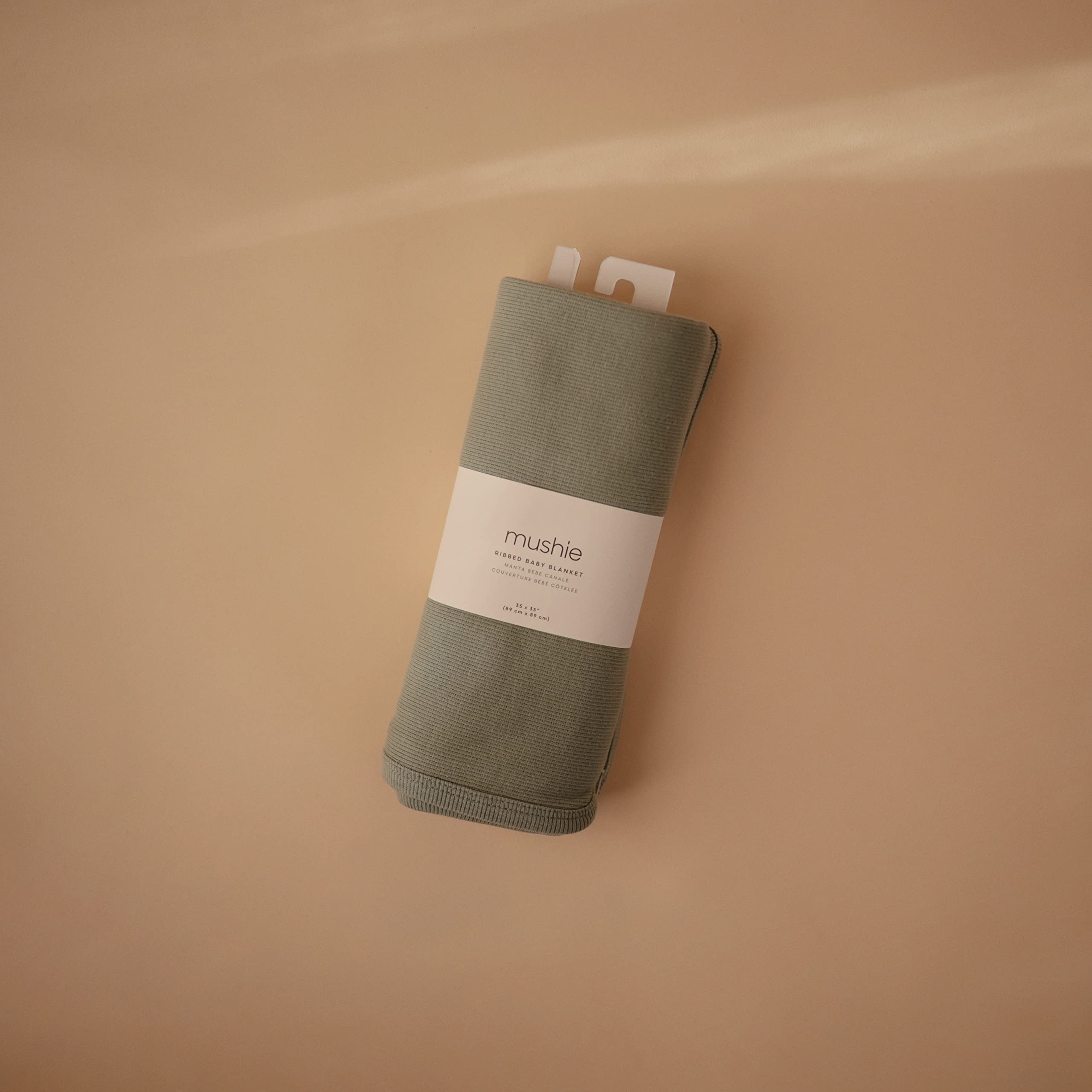 Mushie ribbed blanket swaddle setup demonstrates easy wrap and snug feel