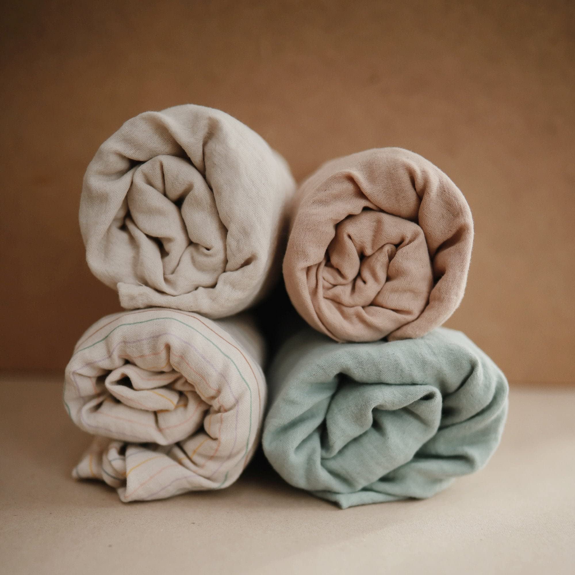 Mushie Roman Green changing pad cover on a standard changing pad for easy daily use.