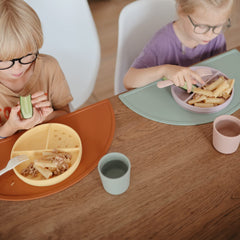 Mushie Sage cups held by small hands during meals.