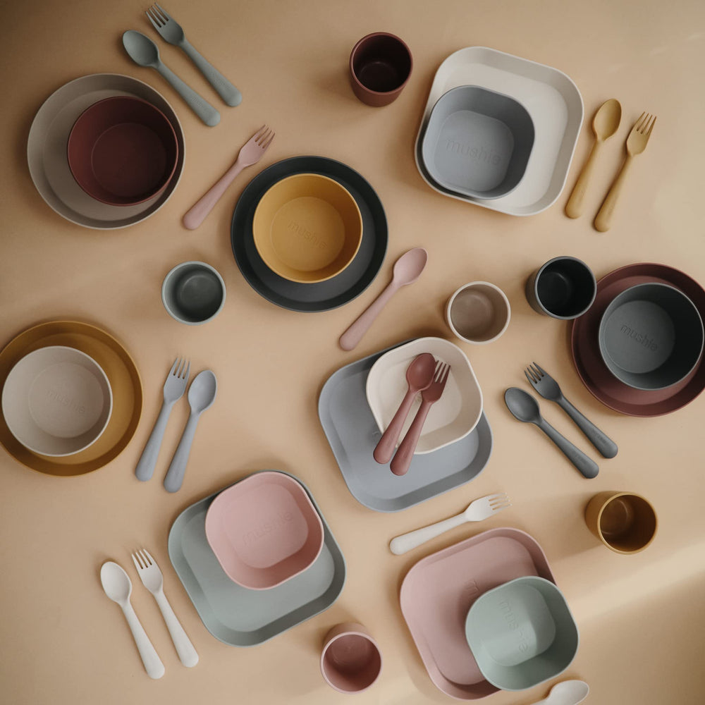 Mushie Sage cups tucked in a pack with other dinnerware.