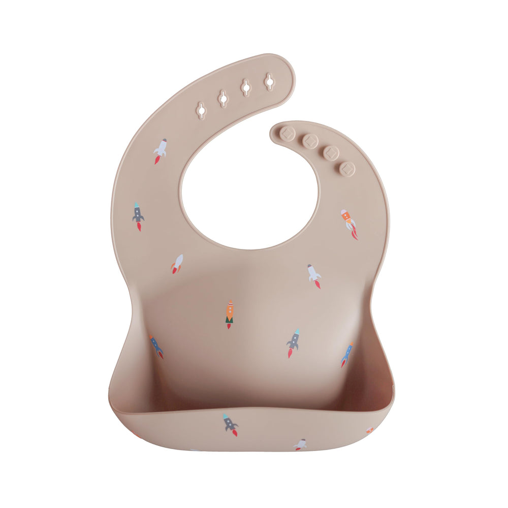 Mushie silicone baby bib rocket ship front view with adjustable fit for comfort