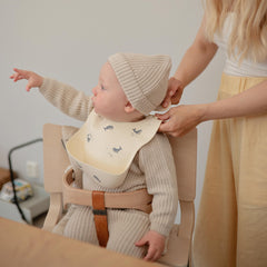 Mushie waterproof bib resists stains and wipes clean after meals.