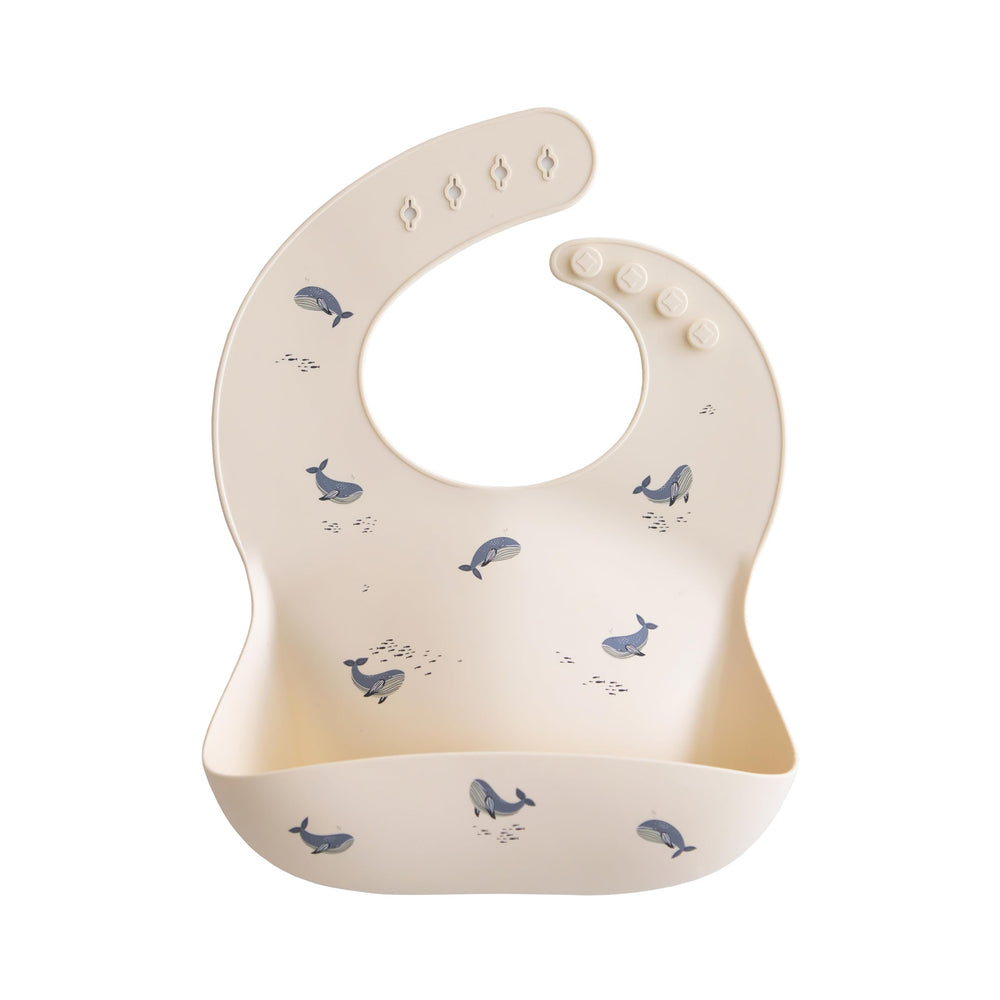 Mushie silicone baby bib in whales pattern keeps mealtimes stylish and tidy.