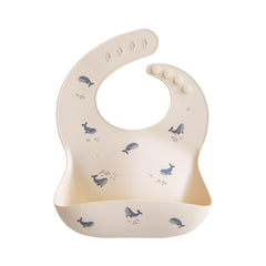 Mushie silicone baby bib in whales pattern keeps mealtimes stylish and tidy.