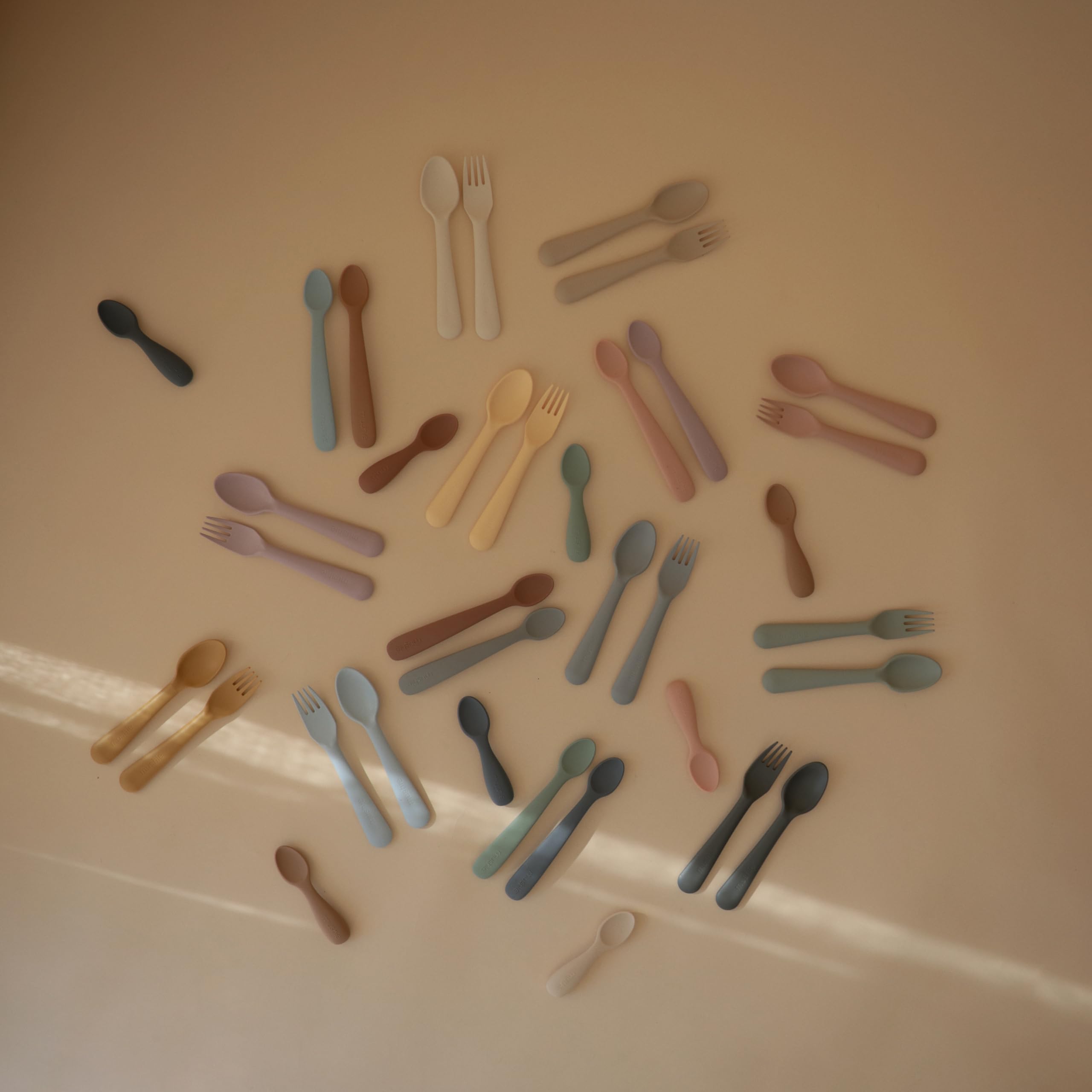 Mushie spoons resting on a tray for quick cleanup.