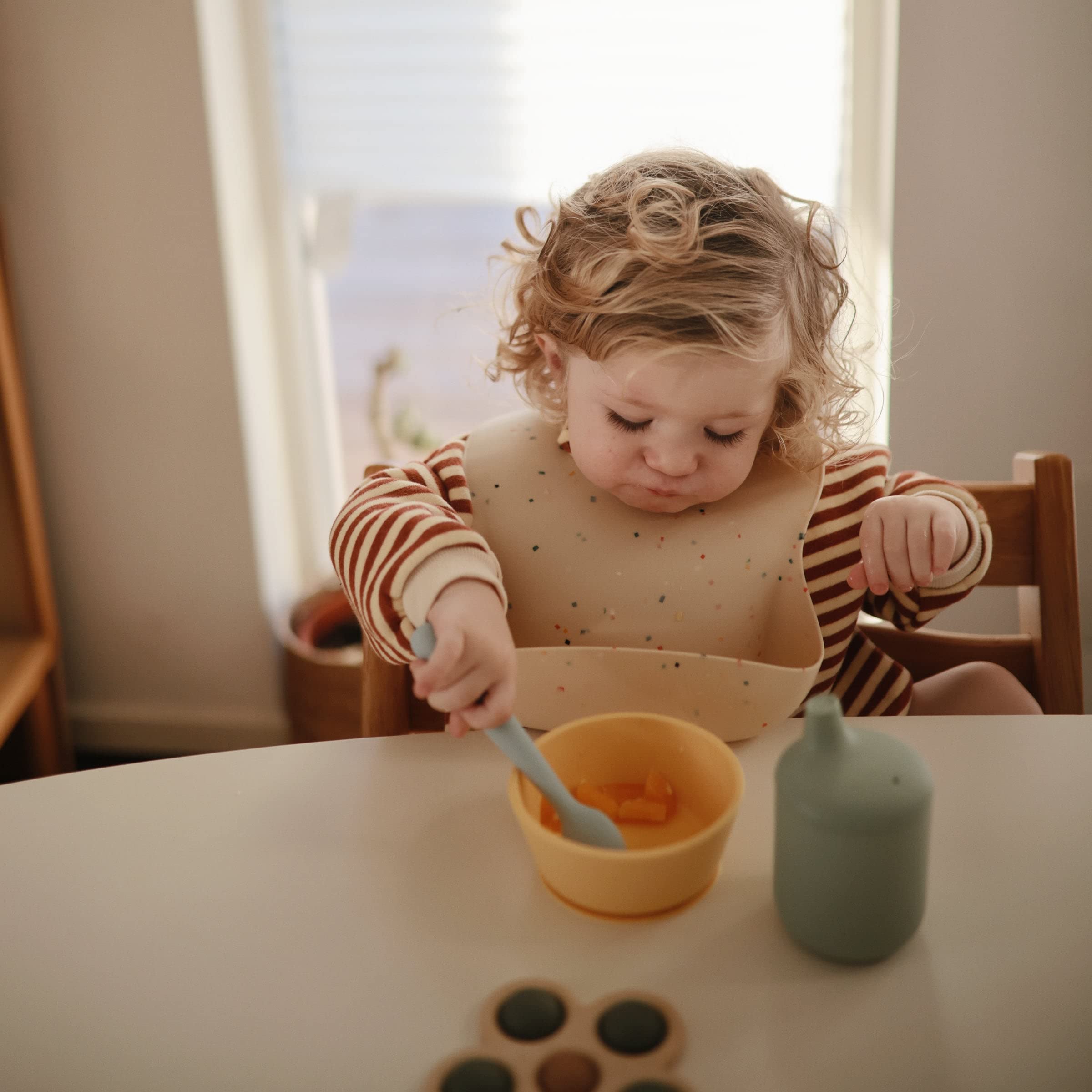 Mushie spoons in a mealtime scene for easy feeding.