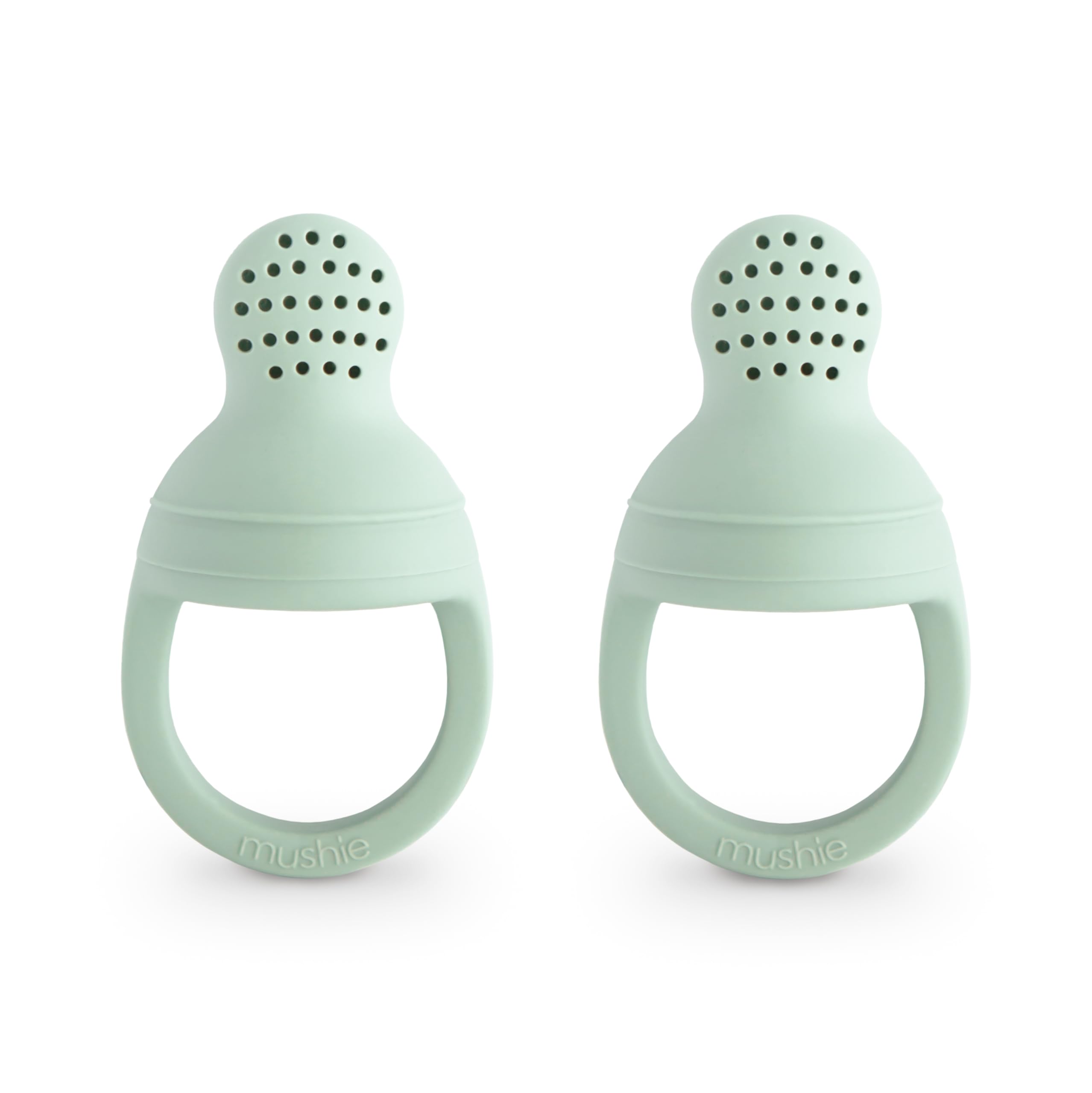 Mushie silicone baby feeder two-pack for safe self-feeding with fresh fruit.