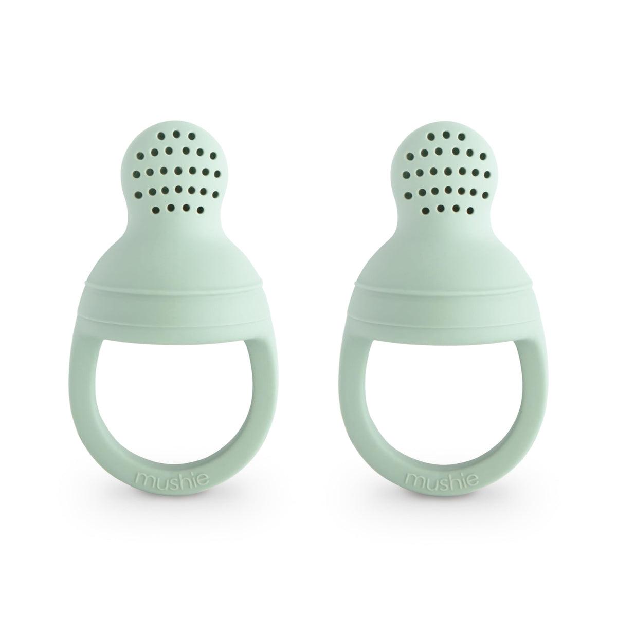 Mushie silicone baby feeder two-pack for safe self-feeding with fresh fruit.