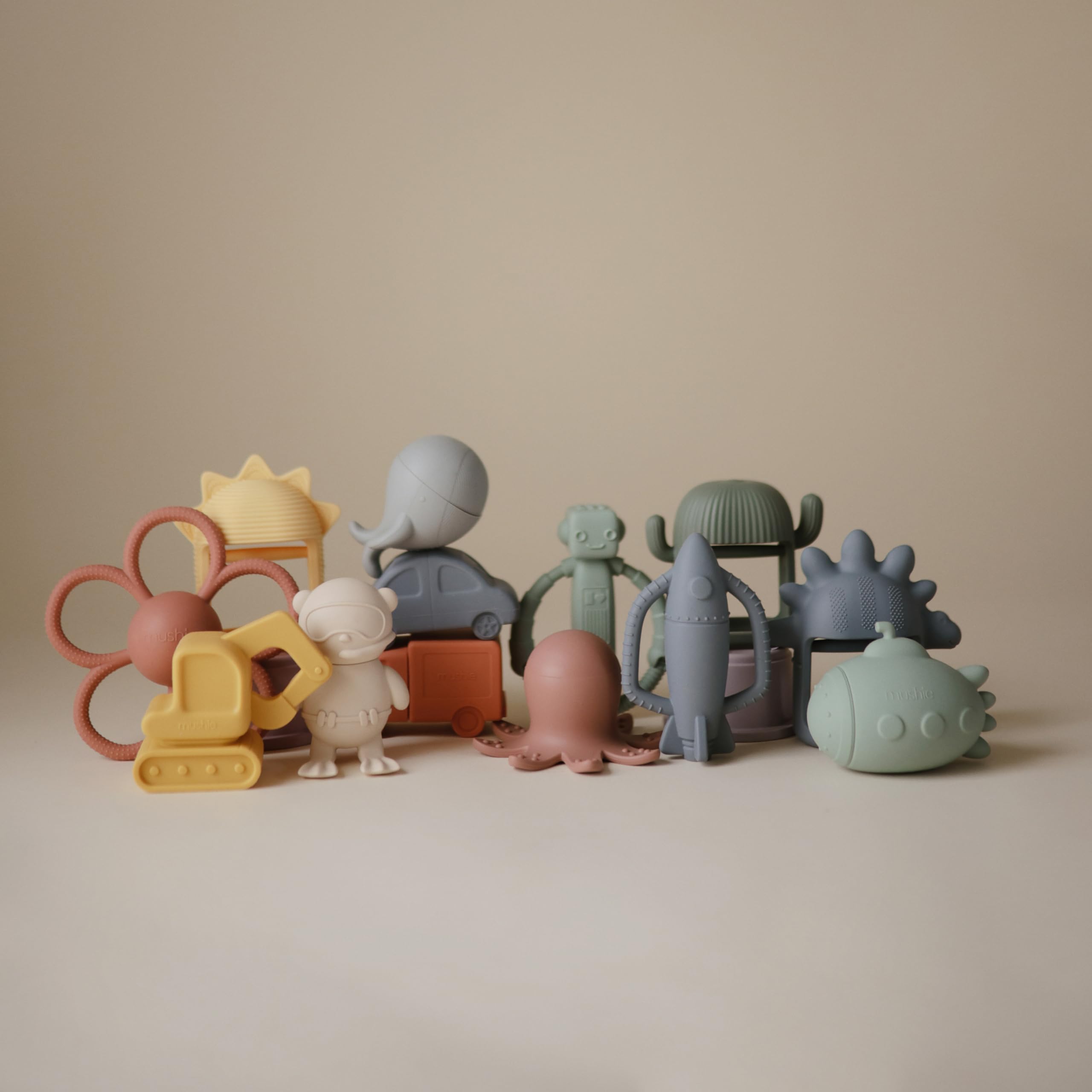 Mushie silicone teether with rattle for audible soothing during play.