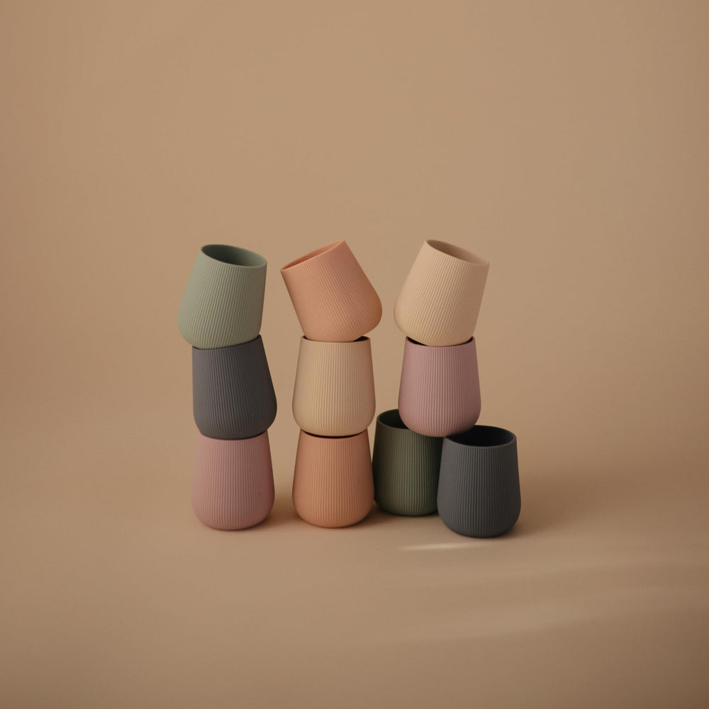Ergonomic design supports little hands during cup practice with Mushie.