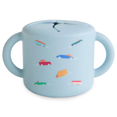 Mushie silicone snack cup on the go with a spill-proof design.