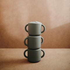 Mushie silicone snack cup side view in thyme color for kid-friendly dining.