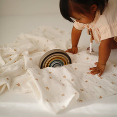 Mushie Sparrow muslin swaddle offers nursery-ready versatility for swaddling, nursing, and cuddling.