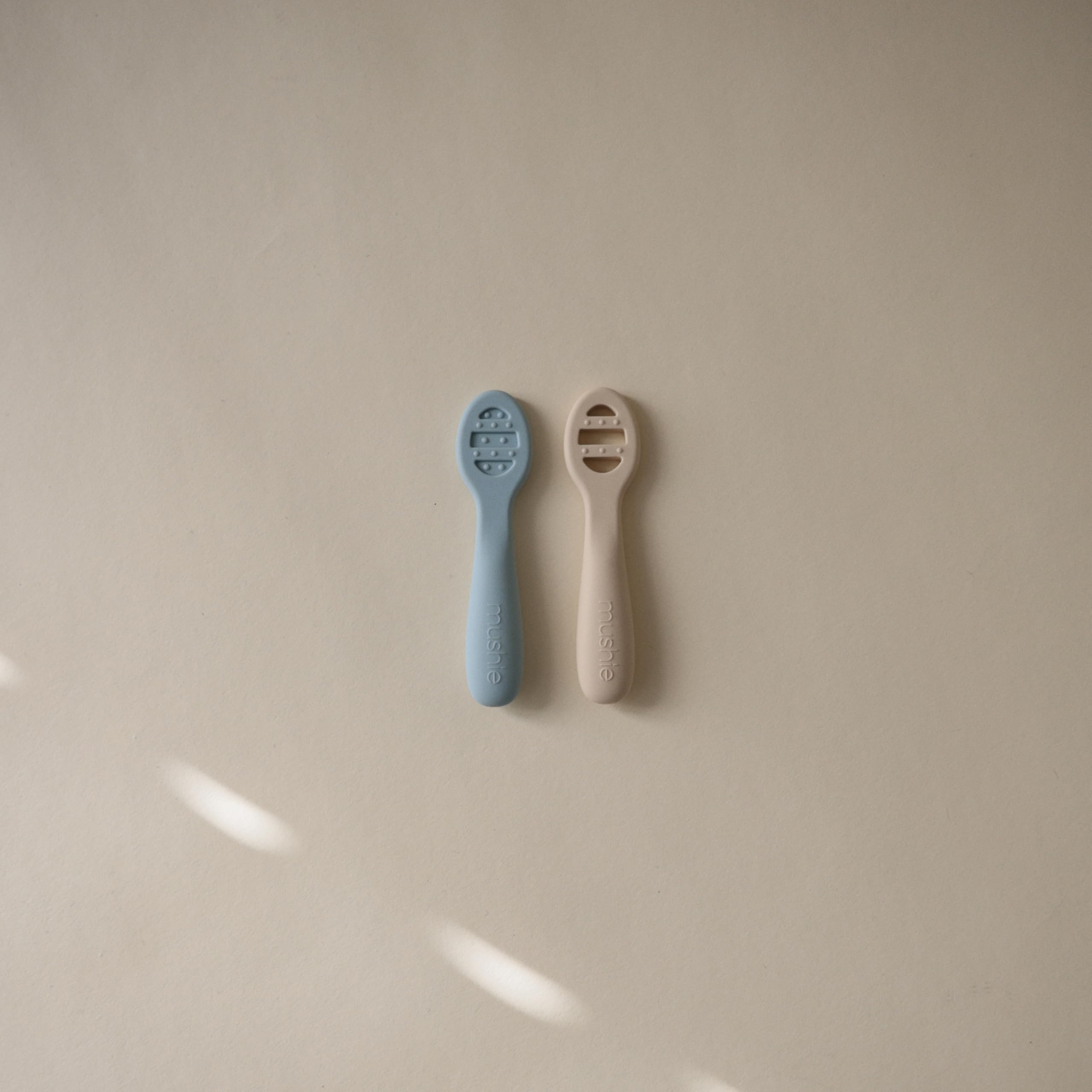 Mushie stage-1 spoon solid surface supports thin purees for careful self-feeding sessions.
