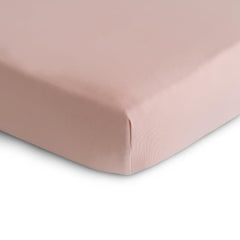 Mushie blush crib sheet with elastic edges showing secure fit