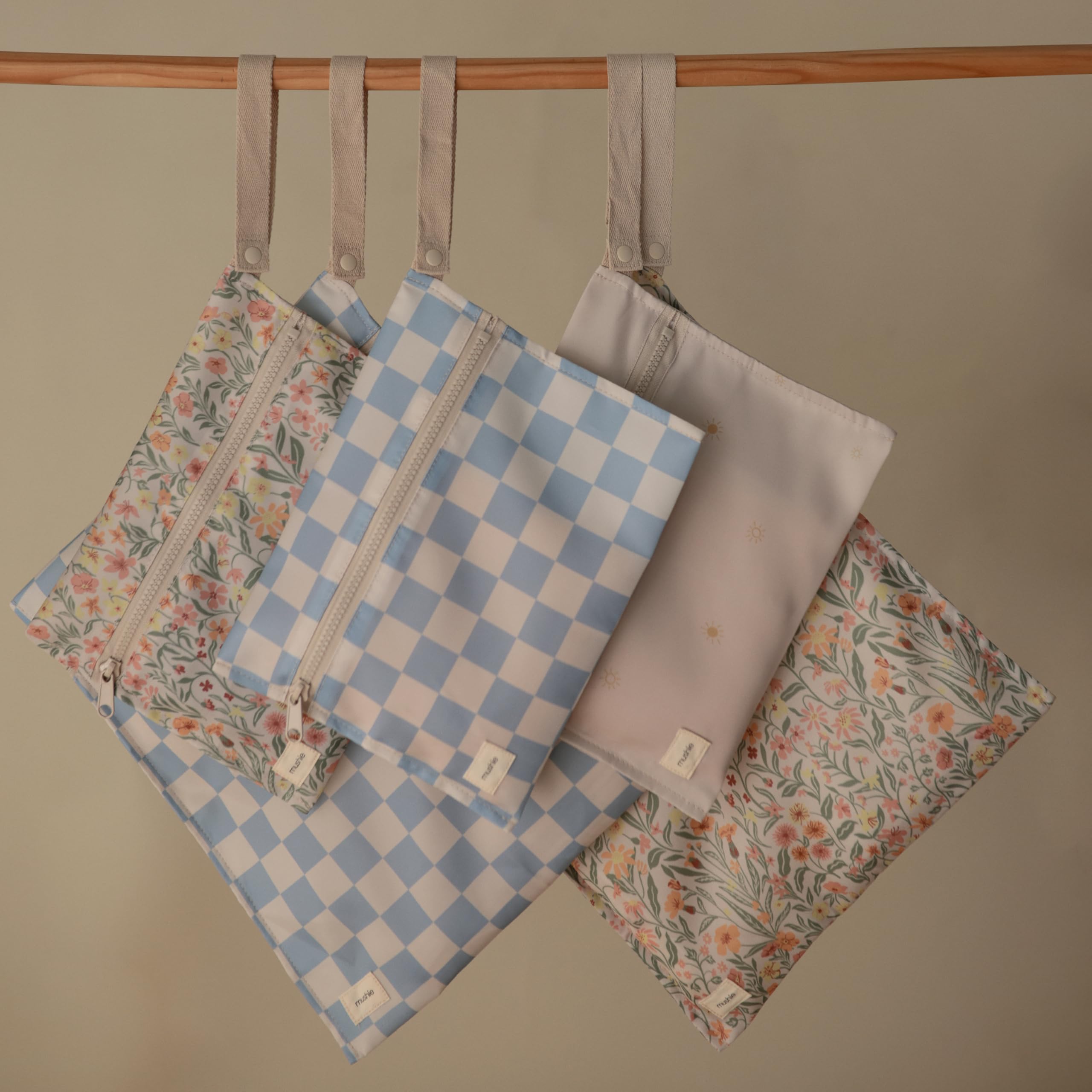 Mushie blue-check wet bag open view with handle for stroller attachment.