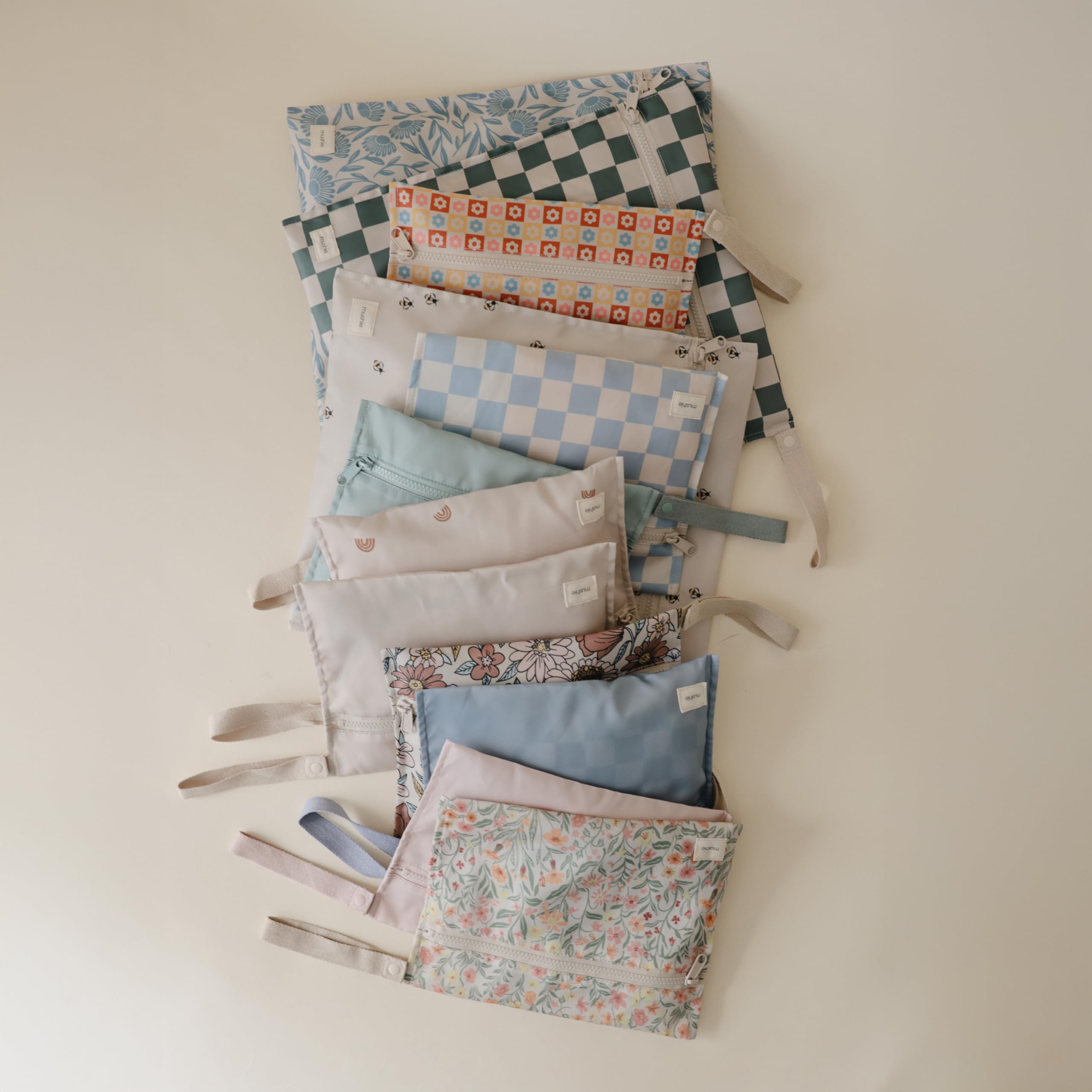 Mushie wet bags with snap handles for stroller attachment.