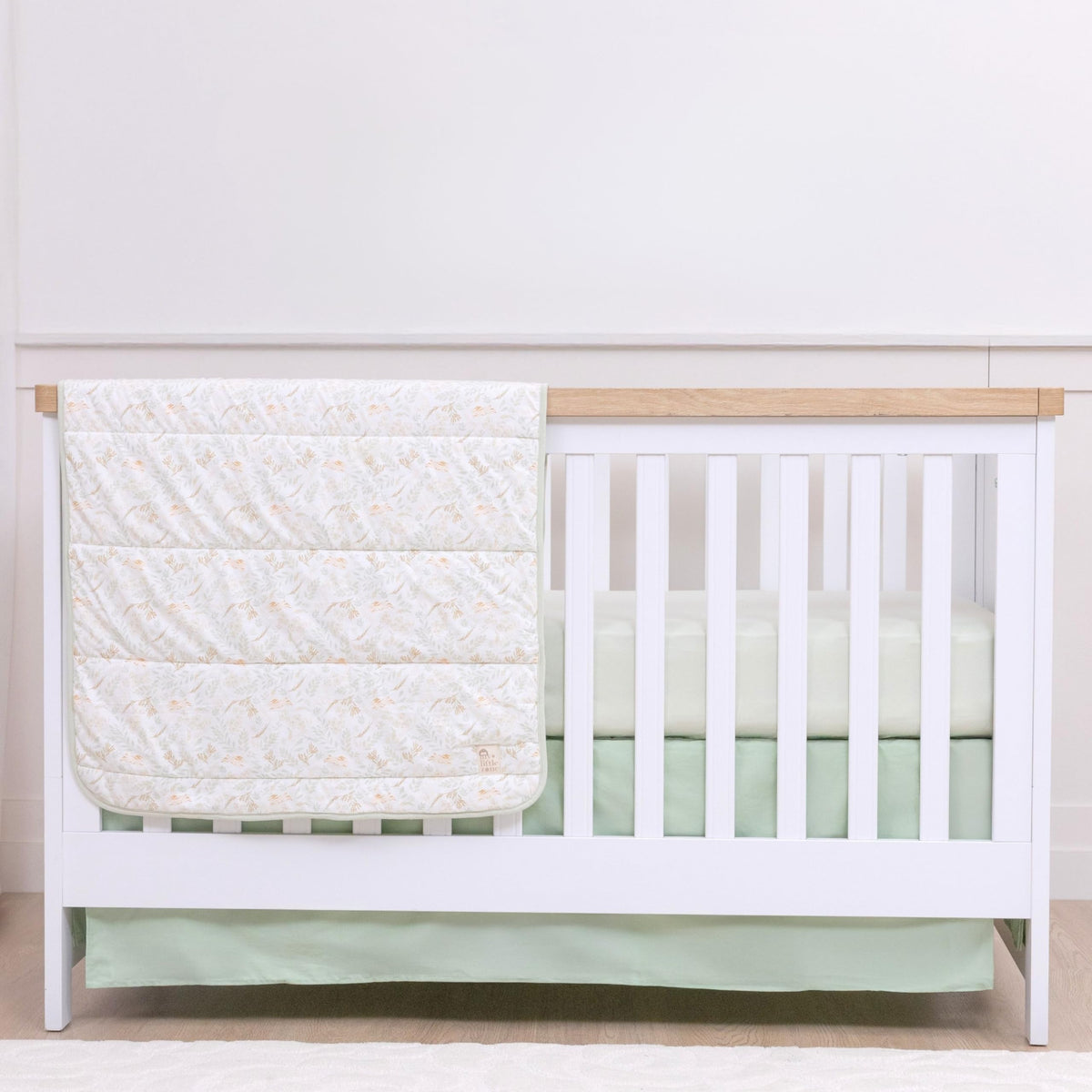 My Little Zone green crib skirt 52x28 on a standard crib hides storage space and adds woodland charm.