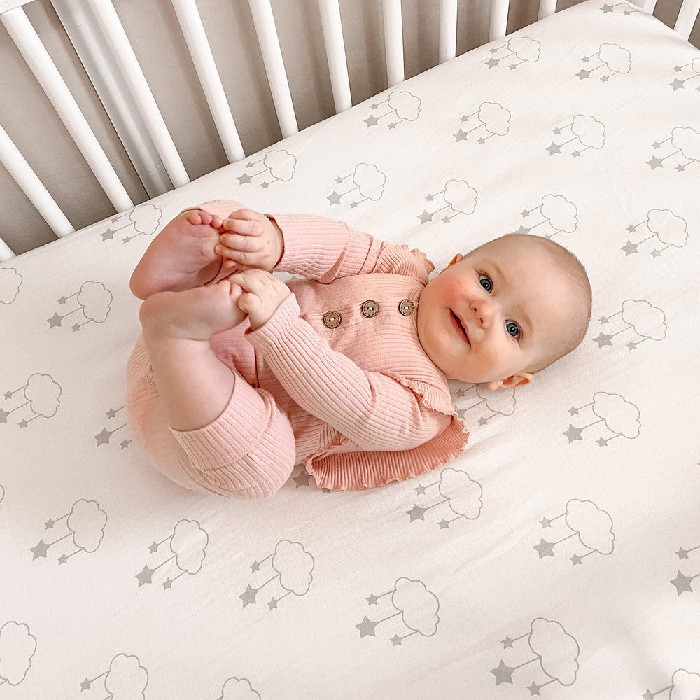 Newton Baby star-print sheet on crib mattress, breathable and gentle for newborns.