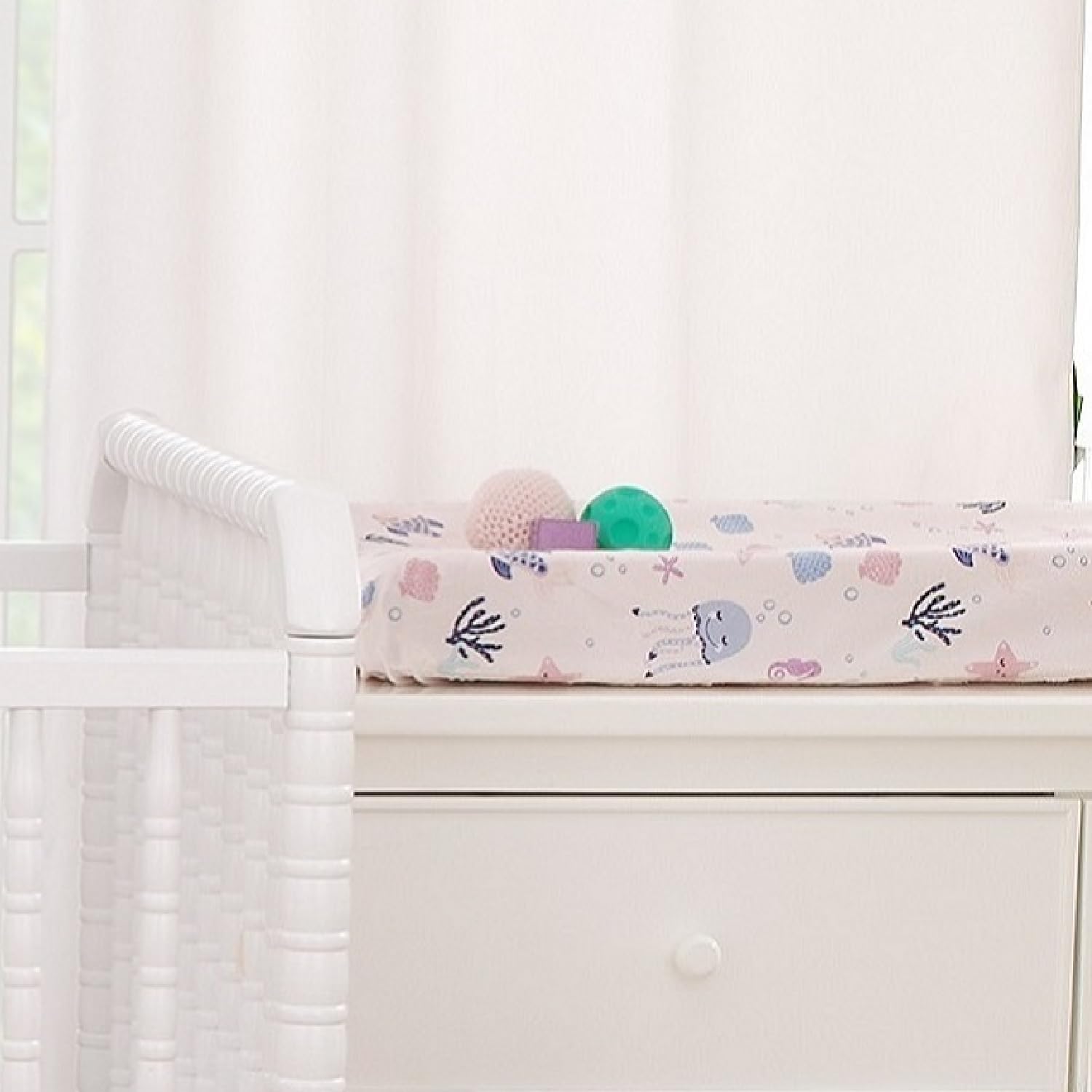 NoJo Mermaid Lagoon pink fabric with ocean motif enhances nursery decor.