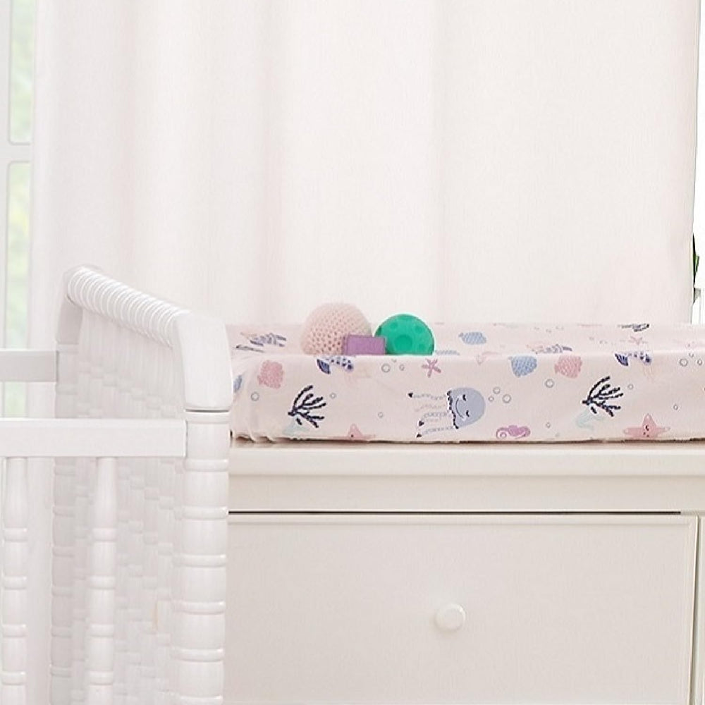NoJo Mermaid Lagoon pink fabric with ocean motif enhances nursery decor.