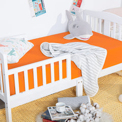 NTBAY orange crib sheet on standard crib mattress showing secure fit.