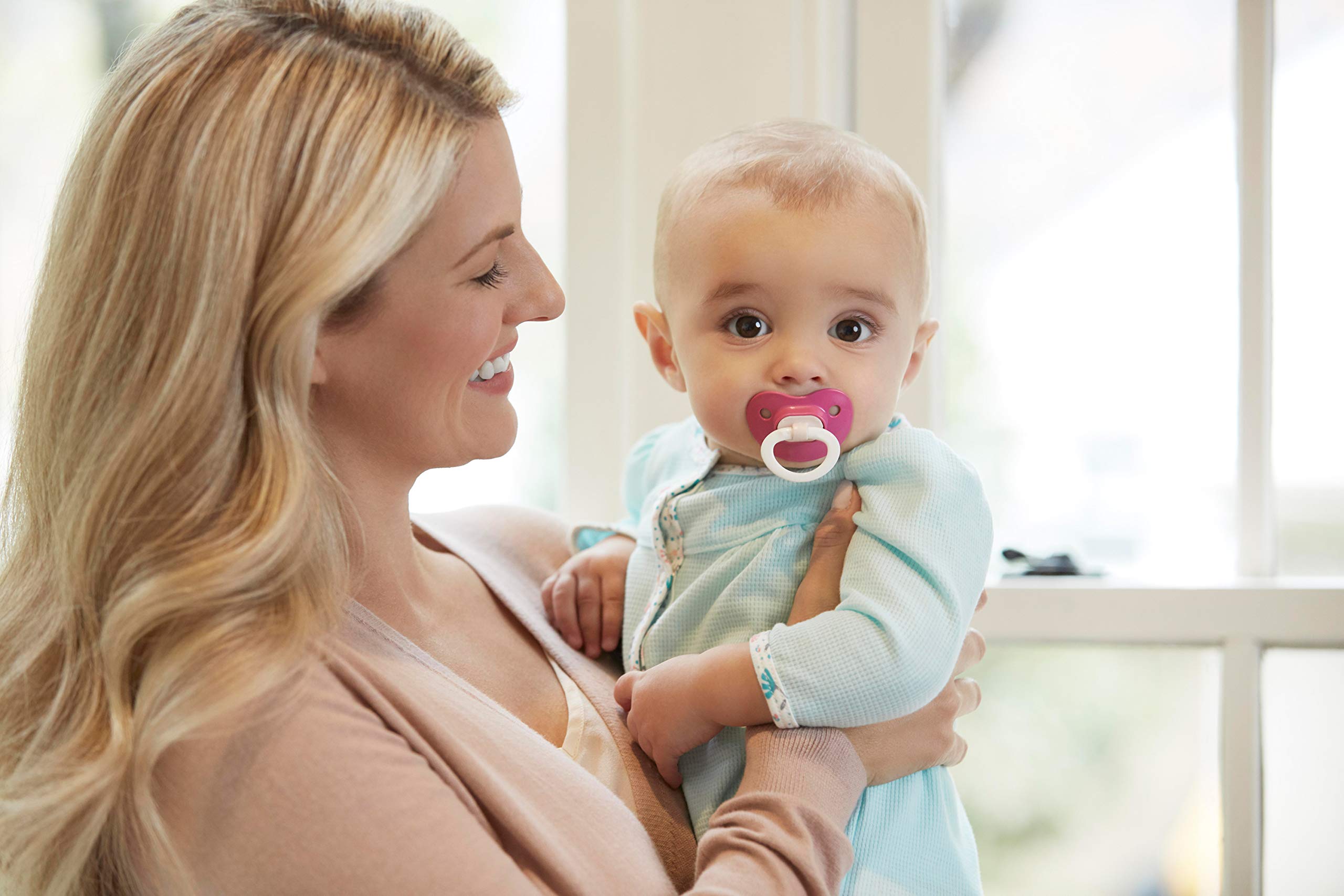 Baby using NUK orthodontic pacifier for comfort and transition.