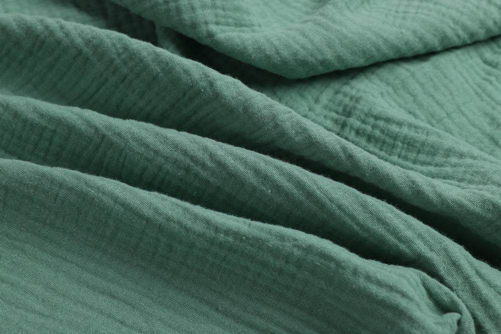 Close-up of soft cotton muslin texture on Onacosht bassinet sheets