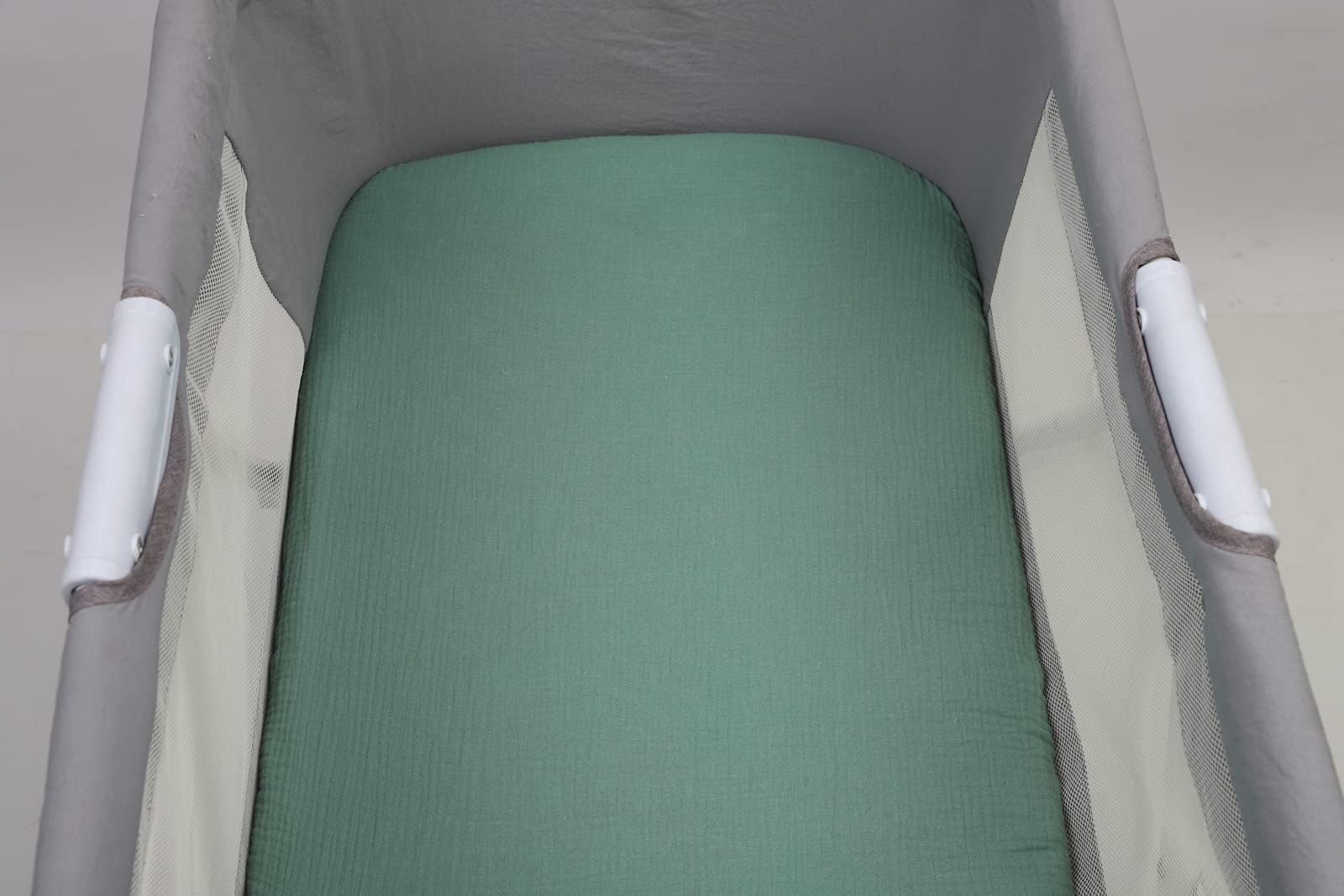 Solid green Onacosht bassinet sheet coordinating with nursery textiles