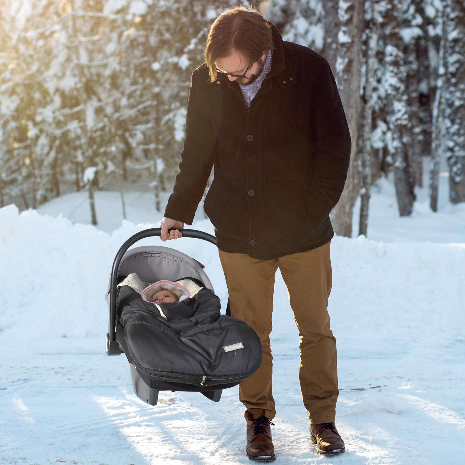 Orzbow in-use image shows cozy baby snug under winter canopy.
