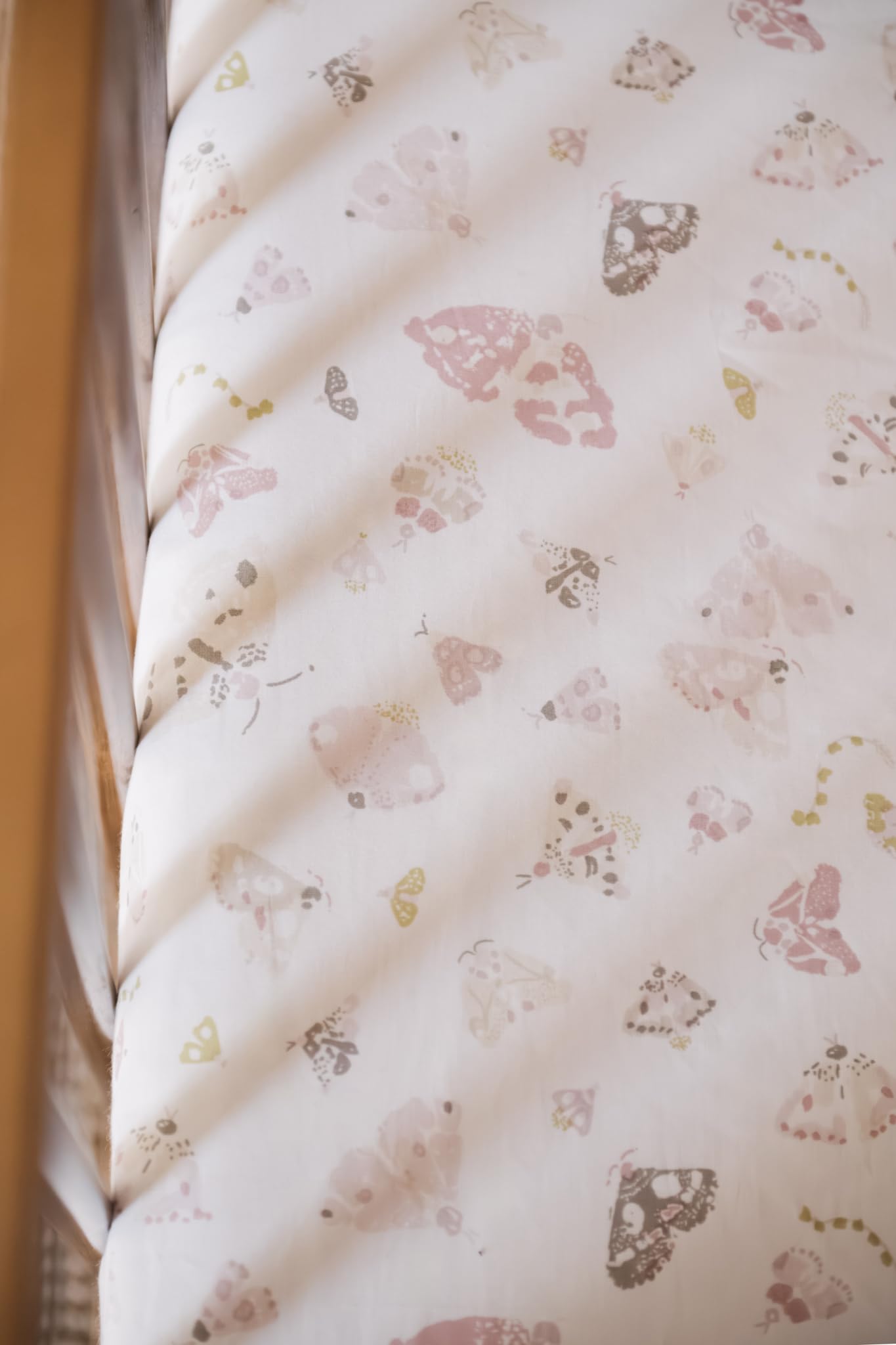 Pehr Daydreamer crib sheet on standard crib mattress showing snug elastic fit