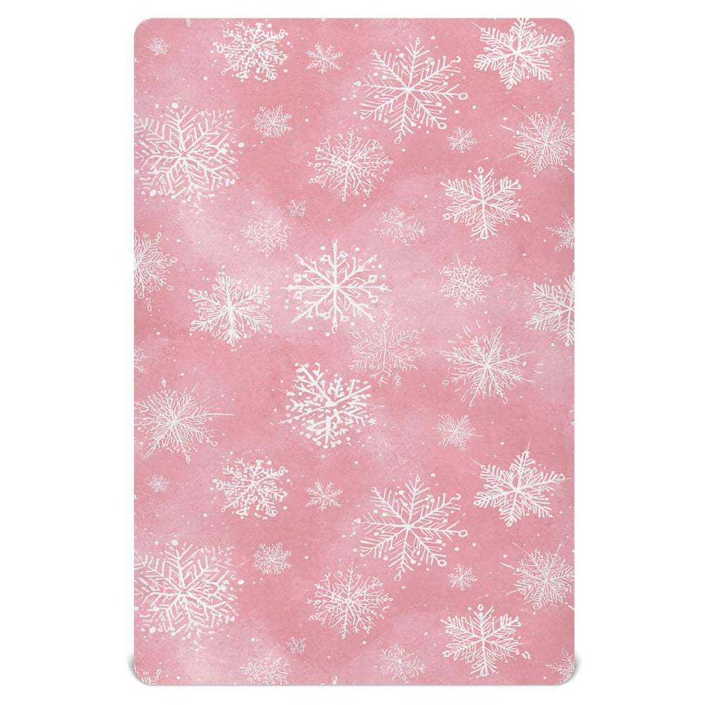Pfrewn Christmas crib sheet with pink retro snowflakes on a mini crib for cozy naps