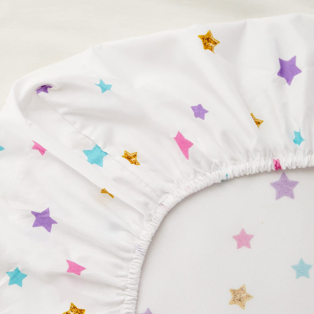 PINNKKU fitted sheet close-up with snug elastic fit for crib mattress